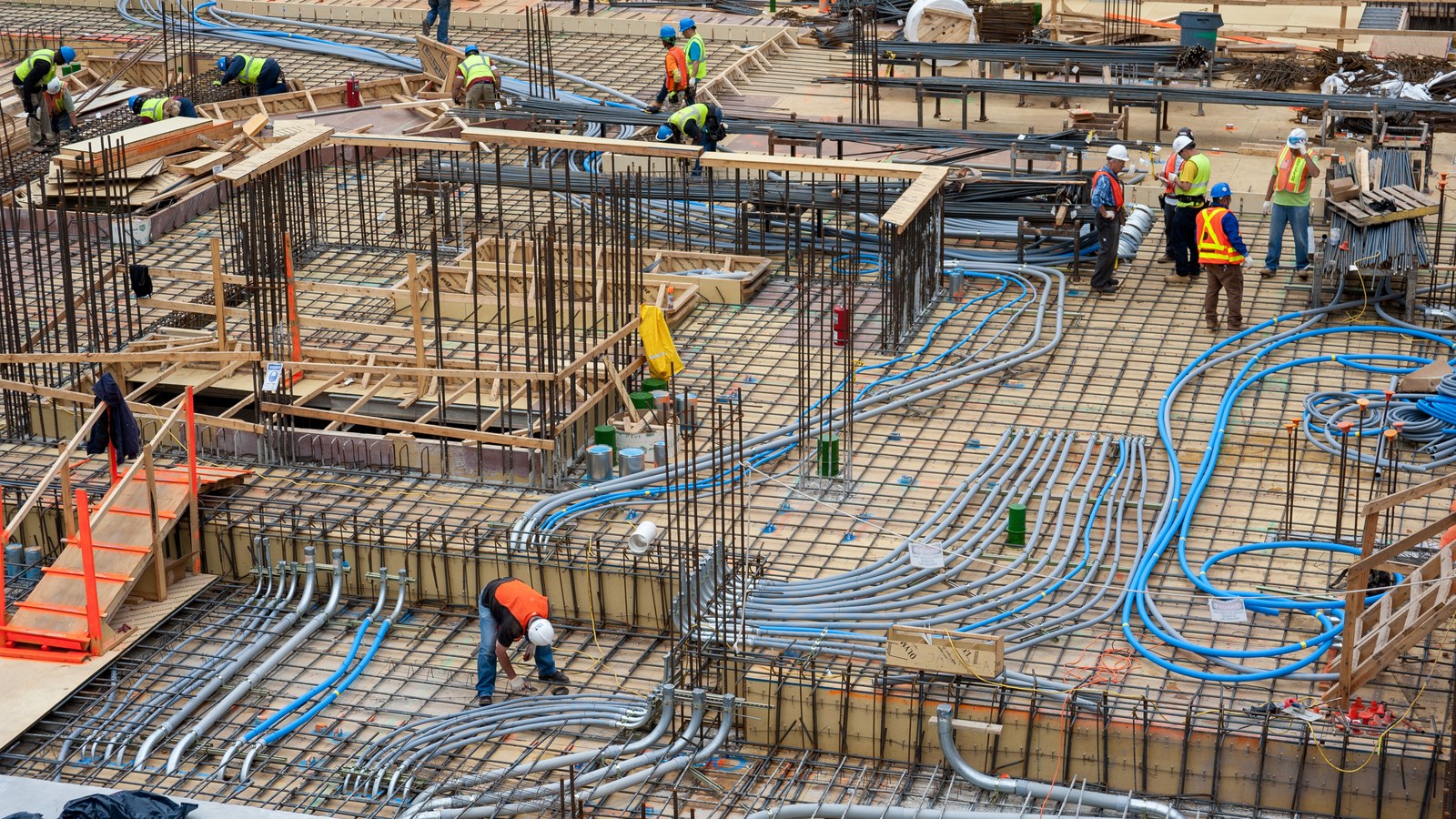 Overhead view of MEP conduit and piping installation at a construction site